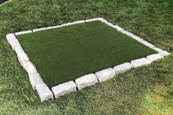 Metro New York Tee box made of synthetic grass surrounded by stone border